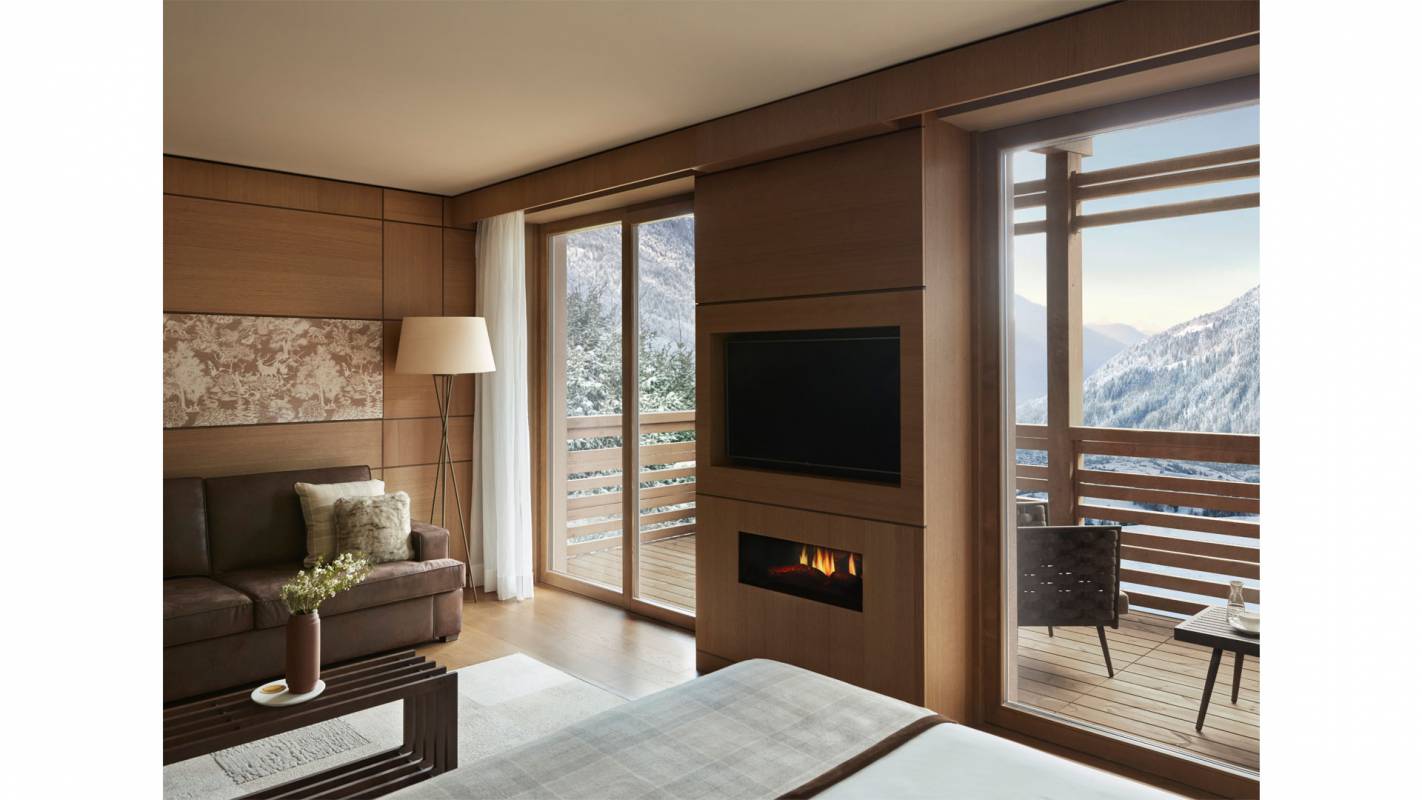 Zimmer mit Kamin und einem großen Balkon mit Blick auf die Dolomiten